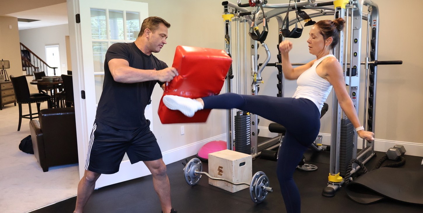 Personal trainer coaching client through kickboxing drill